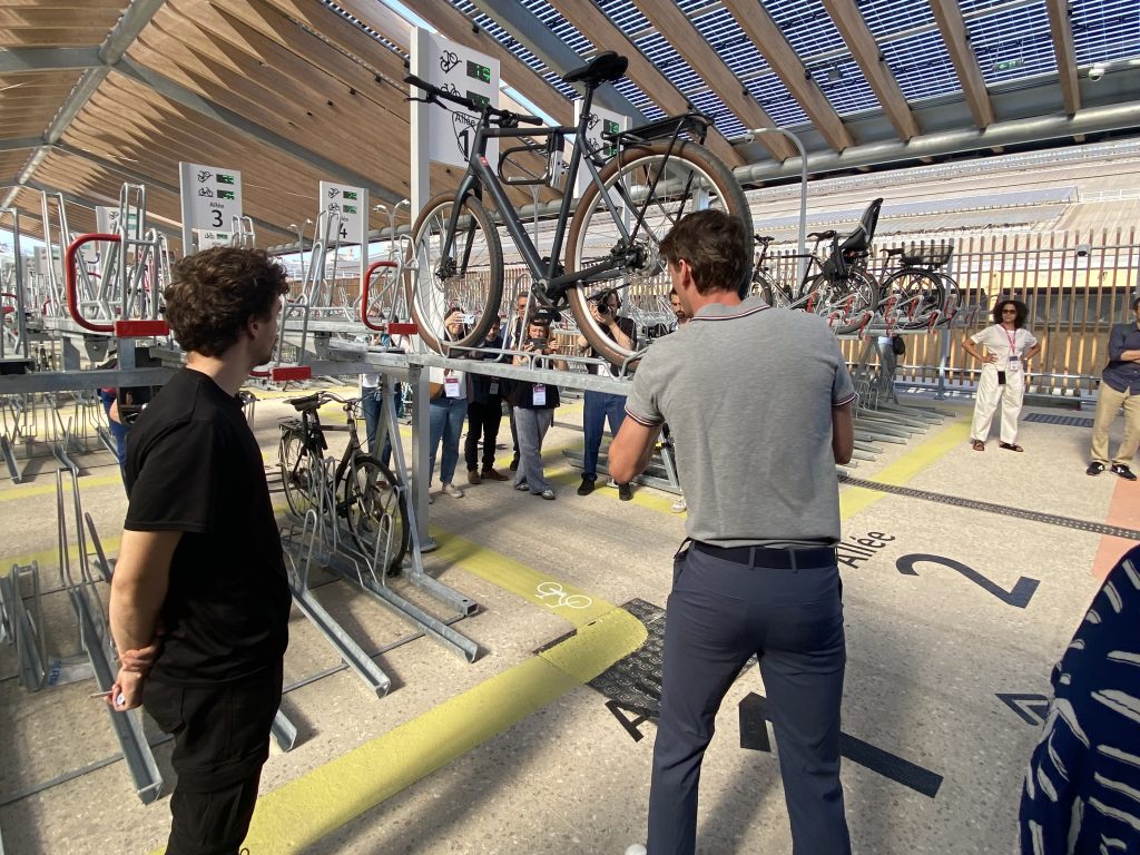 un cycliste stationne son vélo sur un rack de stationnement Optima V10 du parking vélos de la Gare du Nord