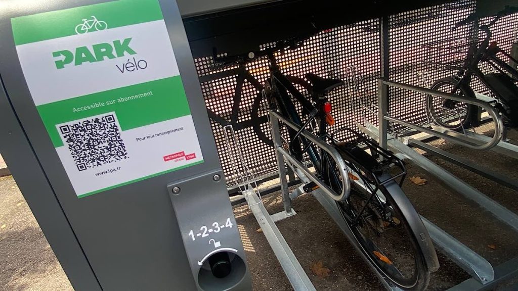 vélo posé et attaché avec antivol sur un arceau à l'intérieur du box ALTAO Pod du service Park Vélo de la Métropole de Lyon